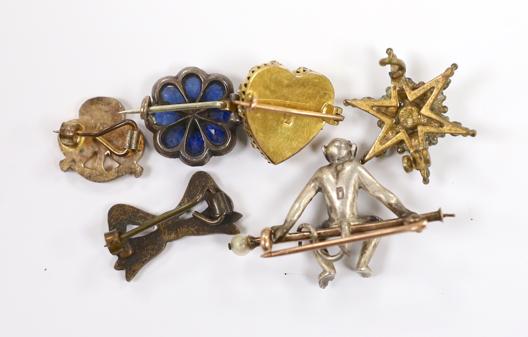 A 9ct and two colour paste set heart shaped brooch, width 15mm and five other assorted brooches, including blue paste and marcasite, paste set seated monkey and paste set starburst.